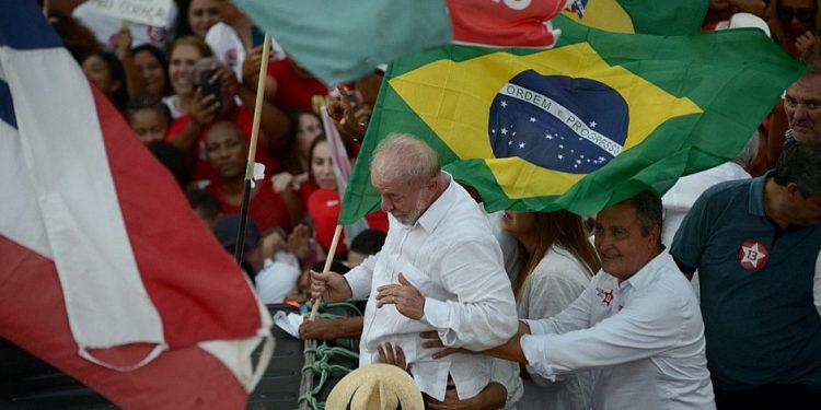 Apoiadores acompanham Lula em caminhada na orla da Barra